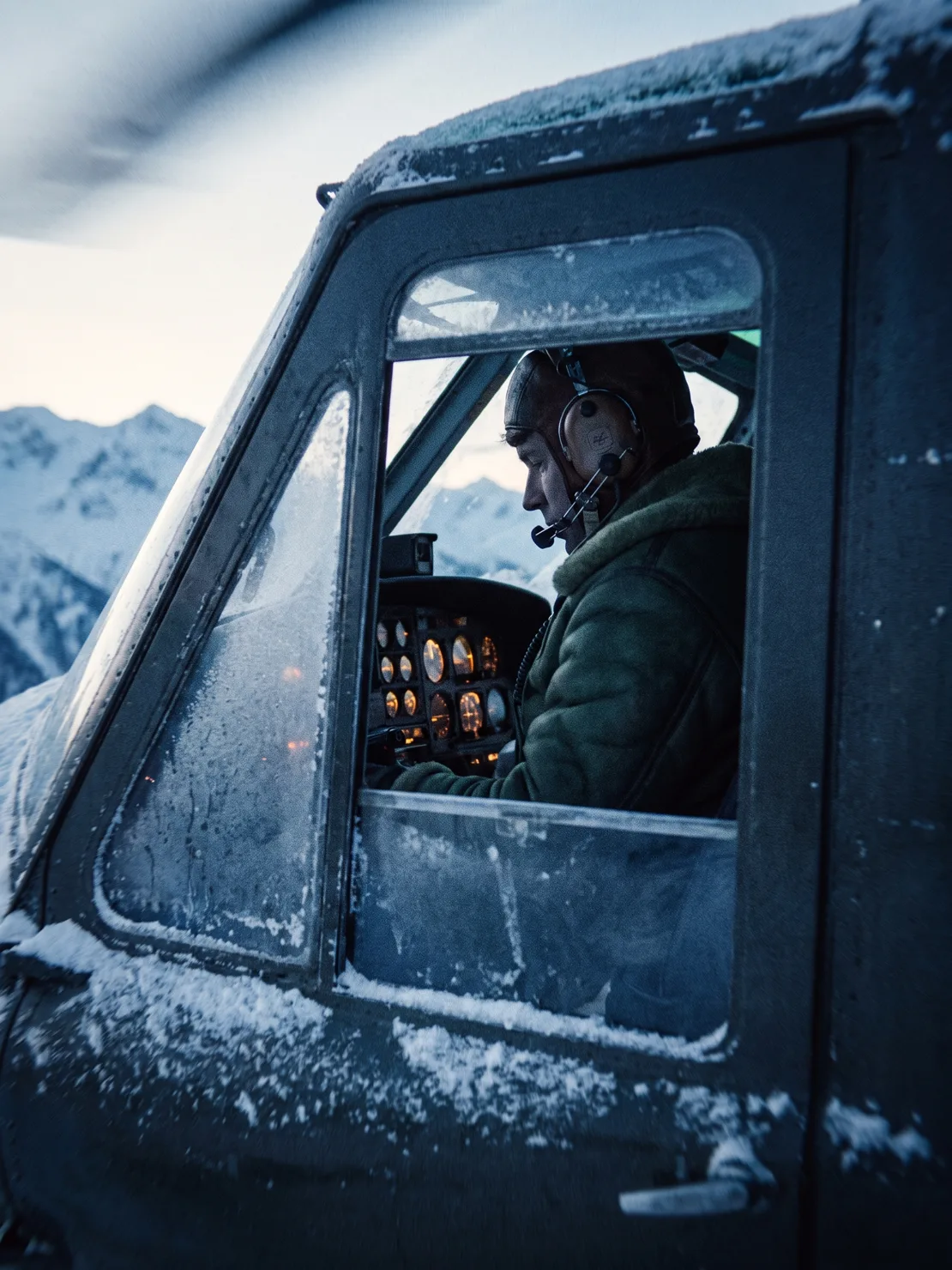 Marta Eriksen in a winter flight jacket and headset, seen through the helicopter's open door during a gauge check at dawn.